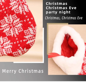 Detail van gebreide rood-witte kerstsok met sneeuwvlokpatroon en imitatiebontrand