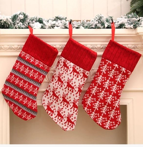 Close-up of knit Christmas stockings with reindeer and snowflake patterns on a fireplace