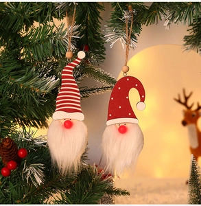 Detail of illuminated Christmas gnome ornaments with red hats hanging on a tree branch