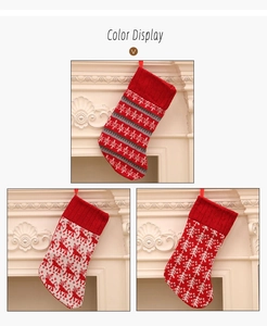 Close-up of knit Christmas stockings with reindeer and snowflake patterns on a white fireplace
