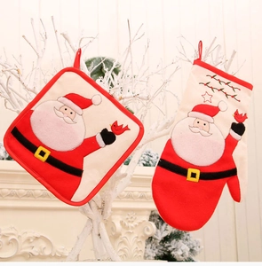 Close-up of Santa Claus themed oven mitt and pot holder with embroidery on white branches
