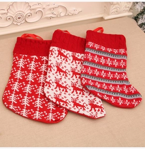 Detail of three knitted Christmas stockings with reindeer and snowflake patterns
