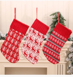Close-up of three knitted Christmas stockings with reindeer and snowflake patterns