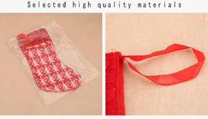 Detail of red knitted Christmas stocking showing white snowflake pattern and silk hanging loop