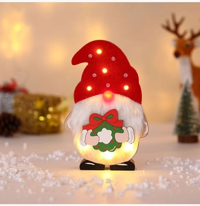 Nahaufnahme eines beleuchteten Weihnachtswichtels mit LED-Licht und Festtagsdeko