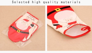 Detail view of red Christmas oven mitt with Santa Claus pattern and white fleece beard