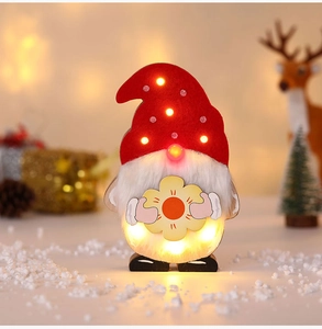Nahaufnahme eines beleuchteten Weihnachts-Gnom-LED-Dekos mit rotem Hut und Sonnenblume