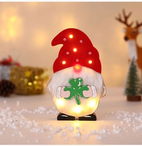 Nahaufnahme der leuchtenden Weihnachtswichtel-Deko mit warmem LED-Licht und Holzfuß