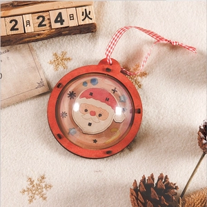 Close-up of wooden Christmas ball ornament with Santa motif and red checkered lanyard