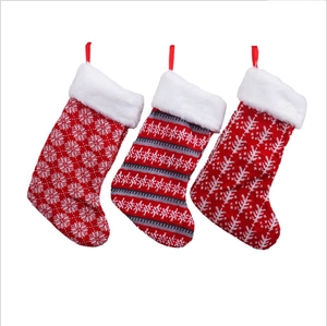 Driedelige set van rood-witte gebreide kerstsokken met pluchen rand om op te hangen