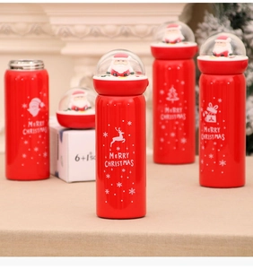 Close-up of red stainless steel thermos with Santa Claus miniature in a clear lid