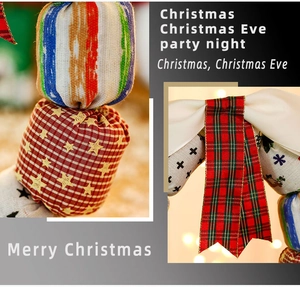 Detailed view of Christmas fabric ornaments and red-green plaid bow with bokeh lights