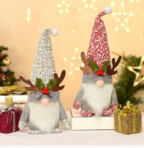 Detail of Christmas gnomes with glittery antlers and festive knit hats on wooden surface