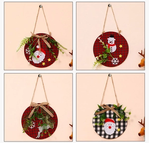 Close-up of four plaid Christmas wooden door signs with Santa, snowman and reindeer decor
