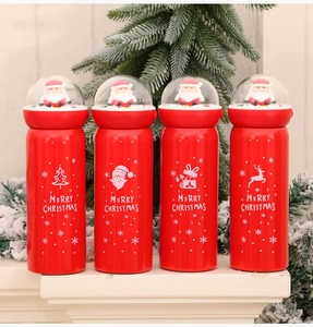 Close-up of red Christmas thermos with a Santa Claus landscape lid and festive patterns
