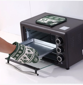 Detailed view of insulated oven mitt lifting a tray with festive reindeer and tree prints