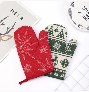 Close-up of Christmas oven mitts with reindeer patterns and quilted cotton texture