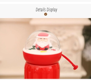 Detail of Christmas thermos lid with Santa Claus figurine and red silicone handle