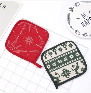 Detailed view of Christmas oven pads with snowflake and reindeer patterns and hanging loops
