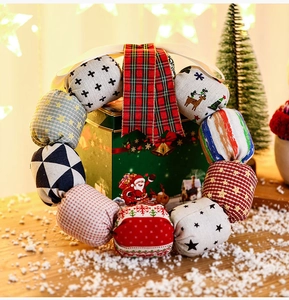 Detail of a handmade Christmas fabric ball wreath with festive plaid ribbons and cozy Nordic style