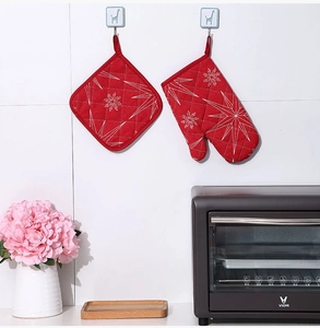 Detail of red Christmas oven mitt and pot holder set with white snowflake patterns