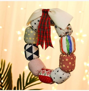 Close-up of Christmas fabric wreath with colorful patterned balls and festive bows
