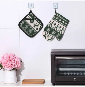 Close-up of Christmas oven mitt and potholder set with reindeer and snowflake patterns
