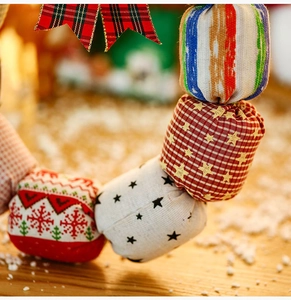 Detail of Christmas fabric ball wreath with festive patterns and a plaid ribbon bow