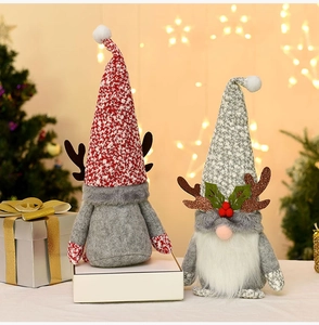 Close-up of plush Christmas gnomes with brown antlers and festive knit textures
