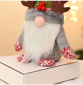 Close-up of a Christmas gnome with brown reindeer antlers and a red knit hat decoration