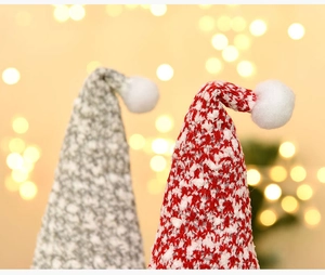 Macro detail of red and grey knitted Christmas gnome hats with plush pom-poms and bokeh lights