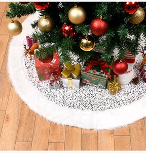 Detail of white plush Christmas tree skirt with shimmering sequins on wooden floor