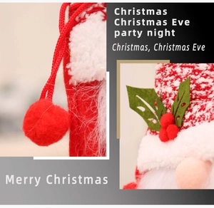 Detail of red Christmas gnome gift bag featuring plush white beard and knitted drawstring