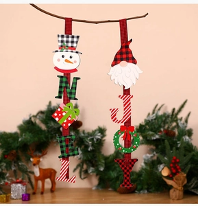 Dettaglio di decorazioni natalizie in legno Noel e Joy con motivi scozzesi su un ramo