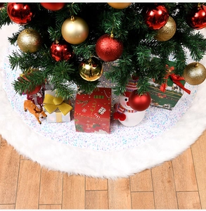 Close-up of white plush Christmas tree skirt with colorful sequins and soft faux fur trim