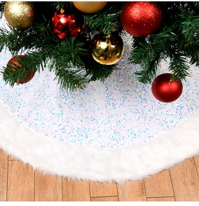 Detail of white plush Christmas tree skirt with iridescent sequins on wooden floor