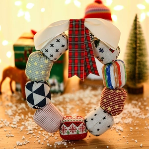 Handcrafted Christmas fabric wreath with festive patterns and silk bow for door decor