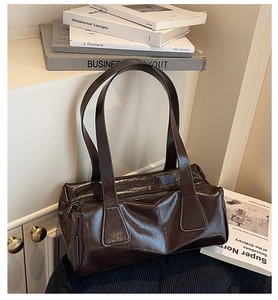 Detail view of glossy dark brown leather shoulder bag with chic vintage texture