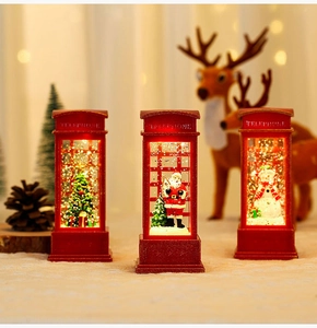 Three red Christmas telephone booth lanterns with snowmen and Santa figurines on white fleece