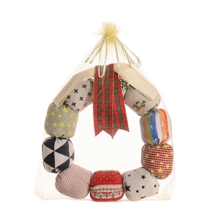 Christmas fabric wreath with plaid patterns and red bow in a beige organza gift bag