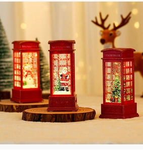 Close-up of vintage red telephone booth snow globe with Santa and warm LED lights