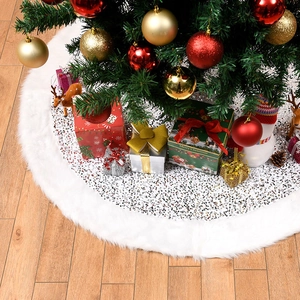 Round white plush Christmas tree skirt with shiny silver sequins on wooden floor