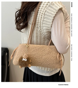 Détail du sac cabas en polaire beige avec un adorable pendentif monstre marron