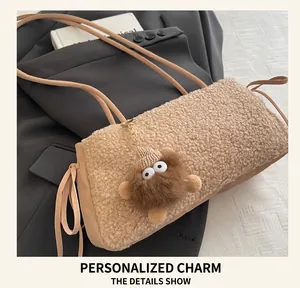 Détail du sac cabas en peluche marron clair avec pendentif monstre rigolo et fines bandoulières
