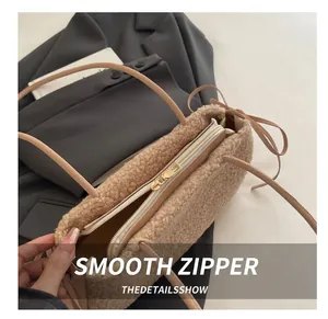 Détail de la fermeture éclair dorée et texture pelucheuse beige sur le sac cabas