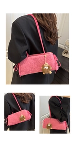 Dettaglio borsa a spalla in peluche rosa con texture in lana d'agnello e ciondolo mostro