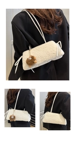 Dettaglio borsa a spalla in pile bianco con cinturino in pelle e ciondolo in peluche marrone