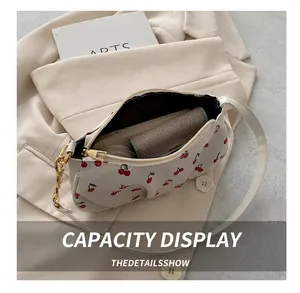 Top view of white cherry print shoulder bag showing internal capacity for phone and wallet