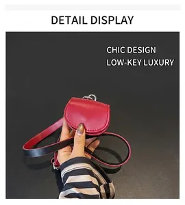 Close-up of a red semi-circle mini bag with textured leather and silver metal ring hardware