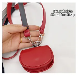 Detail view of the red semi-circular mini bag featuring a detachable shoulder strap